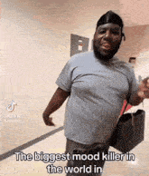 a man is standing in a hallway and says the biggest mood killer in the world in a tiktok video .