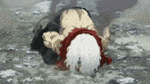 a man with white hair is laying on the ground with a red scarf around his neck