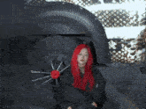 a woman with red hair wearing a leopard print top stands in a hallway surrounded by masked men