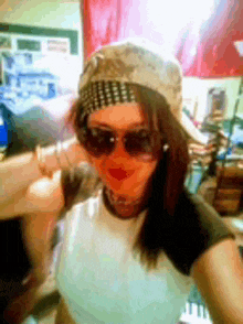 a woman wearing sunglasses and a baseball cap takes a selfie