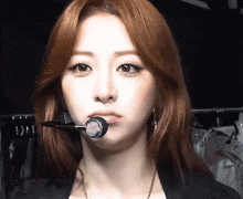 a close up of a woman 's face with a microphone on her mouth