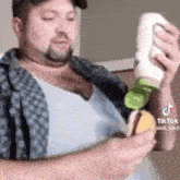 a man is holding a bottle of ketchup and a bottle of mustard .