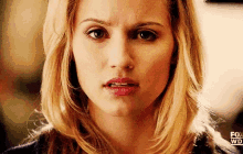 a close up of a woman 's face with a fox logo in the background .