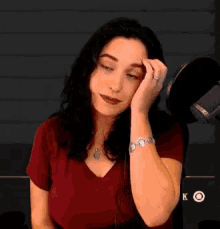a woman sitting in front of a microphone with the letter k on the bottom