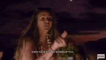 a woman says " own your f *** ing words b * tch " in front of a crowd of people