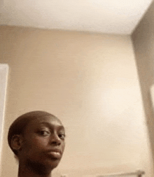 a bald man is taking a selfie in front of a mirror .
