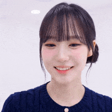 a woman wearing a blue sweater is smiling with her eyes closed
