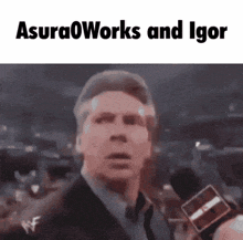 a man in a suit is talking into a microphone with the words asura0works and igor written above him