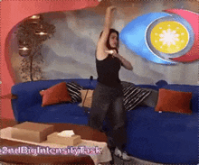 a woman is standing in front of a blue couch with the words 2ndbigintensity task written on the bottom