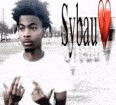 a man in a white shirt is giving the middle finger in front of sybau