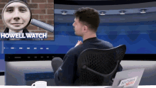 a man sits in front of a tv screen with the words howell watch on it