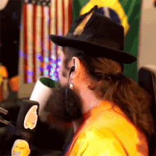 a woman wearing a black hat and ear buds is sitting in front of a microphone