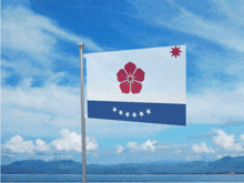 a blue and white flag with a red flower and five stars