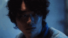 a close up of a man 's face in a blue light
