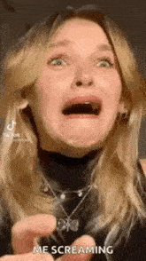 a woman is making a funny face with her mouth open and a necklace around her neck .
