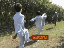 a group of people are standing in a field with a red sign that says ' 家 ' on it