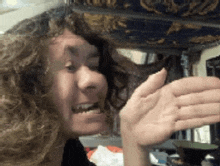 a woman with curly hair is making a funny face