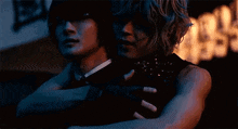 a man and a woman are hugging each other in a dark room .
