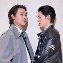 two men are looking at each other and one has a balenciaga jacket on