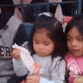 a little girl is holding a piece of paper with the word love on it