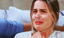 a woman is crying in a hospital bed with an oxygen mask on her nose