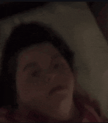 a close up of a child laying on a bed making a face .
