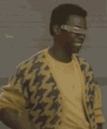 a man wearing a yellow sweater and a pair of futuristic glasses is dancing .