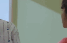 a man in a hospital gown is waving his hand at someone .