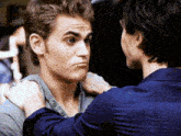 a man with a ring on his finger looks at another man