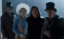 a woman in a hooded cape is surrounded by men in top hats and coats