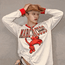 a person wearing a white marc jacobs shirt with a red cat on it