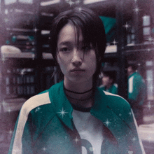 a woman with a nose ring is wearing a teal jacket