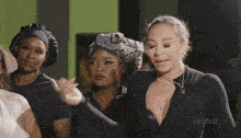 a group of women are standing next to each other in a room wearing black hats .