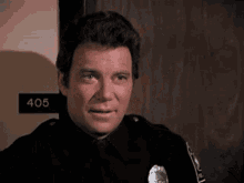 a police officer is smiling and looking at the camera .