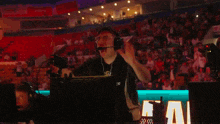 a man wearing a headset and a shirt that says access storage is raising his arms in the air