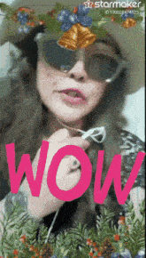 a woman wearing sunglasses and a hat with the word wow in pink