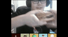 a man wearing headphones is eating a sandwich with a sticker that says ' hawaii ' on it