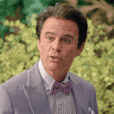 a man wearing a purple suit and a bow tie