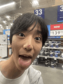 a man making a funny face in front of a sign that says now $ 139.99