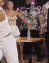 a group of people are standing around a table .