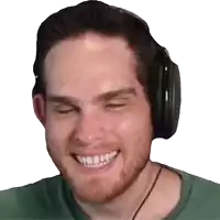 a man wearing headphones and a green shirt smiles with his eyes closed