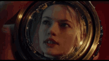 a woman is looking at her face in a mirror