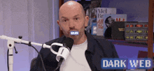 a man is sitting in front of a microphone with the words dark web in the corner