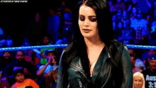 a pixelated image of a woman in a wrestling ring with a crowd in the background .