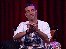 a man wearing a white t-shirt with a joker on it