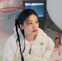 a girl wearing a white umbro hoodie looks at the camera