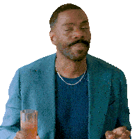 a man in a blue suit is holding a glass of something