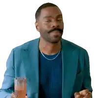a man in a blue suit is holding a glass of something