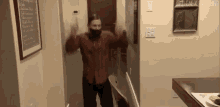 a man wearing a mask is dancing in a hallway with a sign on the wall that says " othenext thing "