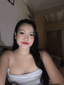 a woman taking a selfie in a room with a sign on the wall that says ' i 'm sorry '
